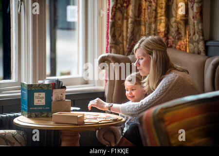 Une mère joue un jeu avec sa fille dans un pub UK Banque D'Images