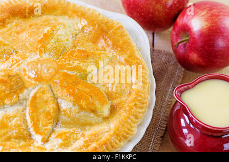Ensemble de la tarte avec un pichet de crème anglaise, selective focus. Prix pour le texte Banque D'Images