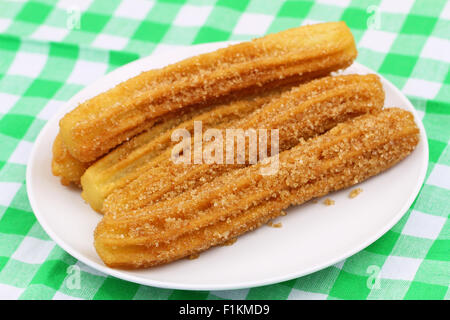 Churros espagnol sur la plaque sur le tissu à carreaux Banque D'Images