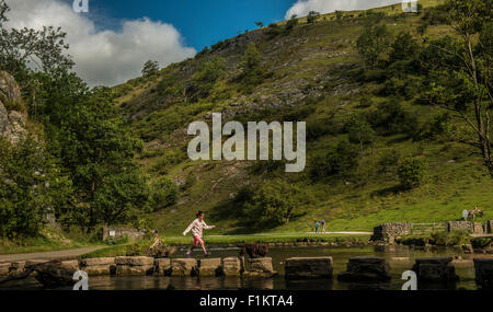 Jeune fille crossing Stepping Stones, Peak District, UK Banque D'Images