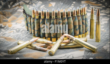 Munitions pour fusil ceinture camouflage sur fond de camouflage. Banque D'Images