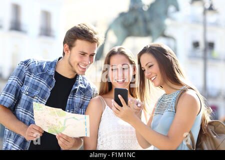 Trois amis touristiques consulting le gps sur téléphone intelligent dans un lieu touristique avec un monument en arrière-plan Banque D'Images