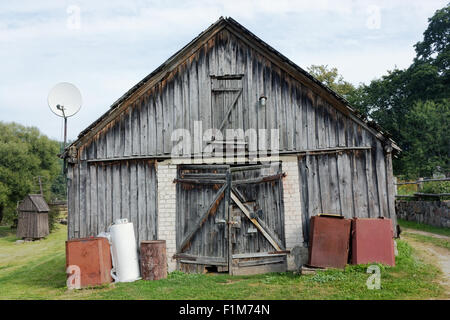 Aucun nom en bois créatifs hangar avec rural avec l'antenne satellite sur le toit. Paysage d'été rustique Banque D'Images