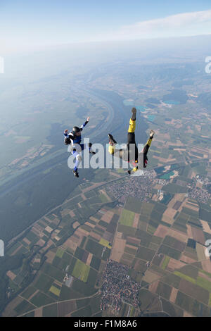 Skydiver volent la tête de au sein d'une équipe dans le sit fly de poste sur une montagne spectaculaire des paysages avec plus de 120 km/h. Banque D'Images