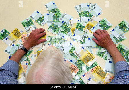 Un homme âgé avec beaucoup de billets sur la table Banque D'Images