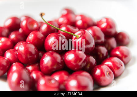 Bol d cerries frais rouge sur fond blanc Banque D'Images