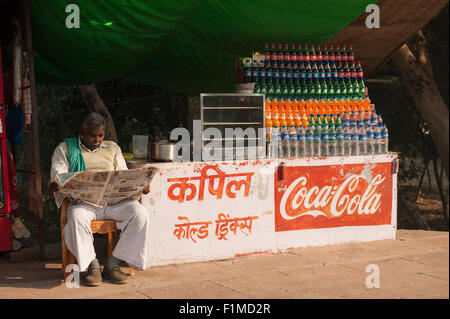 Agra, Utar Pradesh, Inde. Journal de lecture du Vendeur de boissons. Banque D'Images