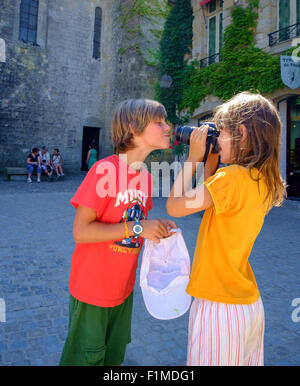 Garçon Fille enfants Les enfants jouant en tenant l'appareil photo Banque D'Images