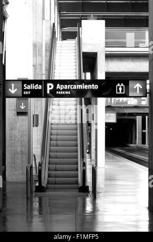 Gare avec balisage et escalators noir et blanc Banque D'Images