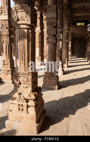 Delhi, Inde. Quwwat-ul-Islam mosquée dans le complexe Qûtb Minâr. Les colonnes sculptées. Banque D'Images