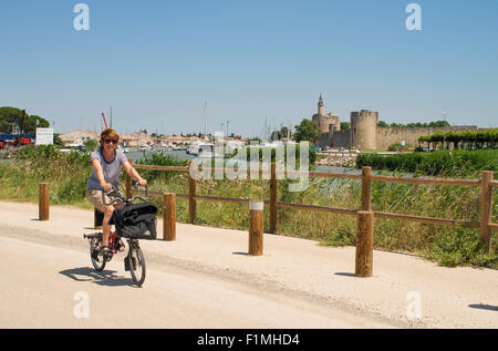 Cycliste féminine à cheval le long de la piste cyclable entre Aigues-Mortes et Le Grau-du-Roi, Languedoc-Roussillon, France, Europe Banque D'Images