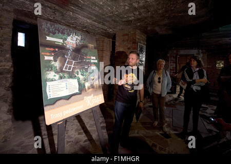 Tour guide Macciej Meissner explique le système de tunnel souterrain sous l'ancien palais de Fuerstenstein Ksiaz (Palace), Walbrzych, Pologne, le 3 septembre 2015. Un char allemand de la Seconde Guerre mondiale est situé à une profondeur de 70 mètres entre les points milliaires 60 et 65 dans une cachette souterraine près de Ksiaz Palace. Selon des légendes locales, deux trains de réservoir, qui ont disparu sans laisser de traces dans les derniers mois de la Seconde Guerre mondiale, lorsqu'elle est cachée dans le repaire souterrain à proximité dans une ancienne mine de charbon. La cargaison du train, cependant, reste l'objet de nombreuses spéculations dans le monde entier. Banque D'Images