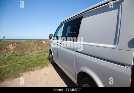 Un livre blanc VW T5 Camping-van garé sur clifftop à Ysgaden Tudweiliog, Porth, péninsule Llyn, au nord du Pays de Galles avec vue sur l'anse Banque D'Images