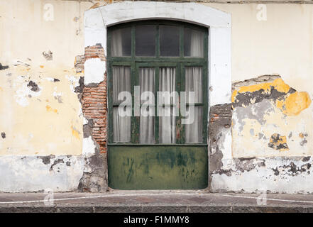 Porte en bois vert foncé dans la vieille façade de l'immeuble. Ischia, Italie Banque D'Images