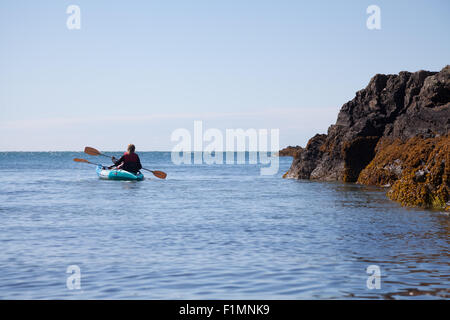 Deux personnes en canoë / kayak kayaks autour de l'anse à Ysgaden Tudweiliog, Porth, péninsule Llyn, au nord du Pays de Galles Banque D'Images