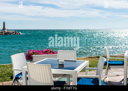 Bar où vous pourrez prendre un verre en regardant la mer avec le phare en pierre à la fin de la jetée de Puerto Banus, Marbella, Espagne Banque D'Images