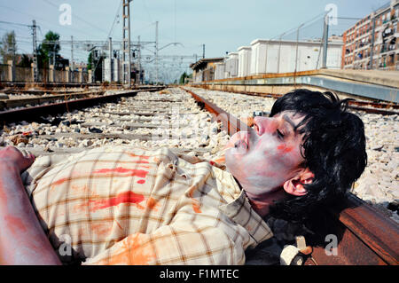 Libre d'un zombie effrayant homme couché sur la voie ferrée Banque D'Images