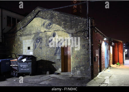 Visage fantomatique. Une peinture murale d'un visage de femme peint sur le pignon d'un ancien bâtiment industriel à Peckham, South East London Banque D'Images