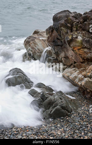 Vague sur les rochers sur Abermawr beach à Pembrokeshire, Pays de Galles. Banque D'Images