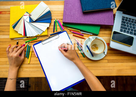 L'écriture avec crayon de couleur sur la feuille de papier blanc Banque D'Images