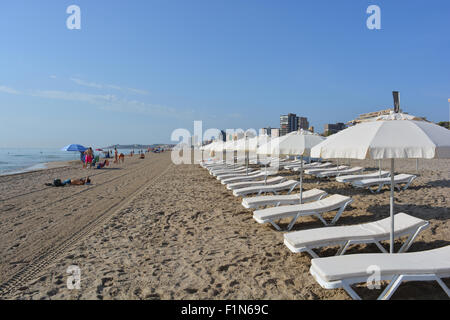 Voir tôt le matin sur la plage à Playa San Juan en direction de la ville d'Alicante, de touristes, de chaises longues et parasols. Banque D'Images