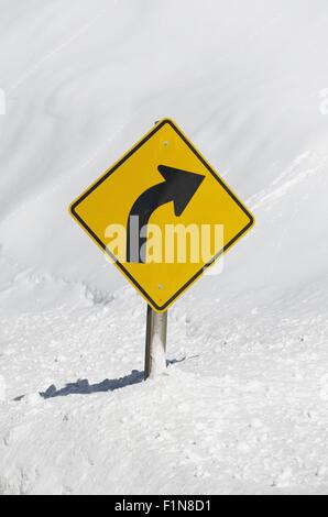 Panneaux Route d'hiver. Panneau de circulation jaune courbe en avant dans la neige. Banque D'Images