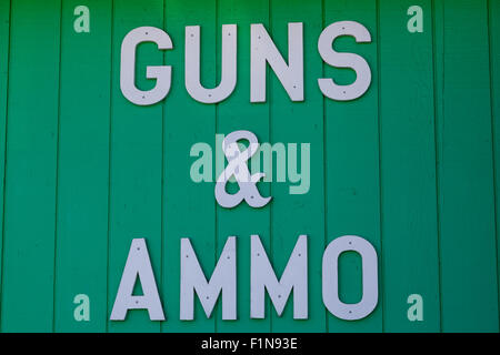 Une silhouette blanche lettre signe cloué à un mur d'un magasin d'armes et de munitions pour fusils publicité vente. Banque D'Images