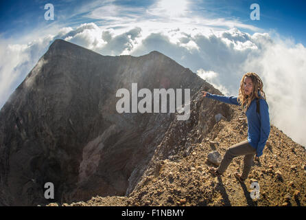 Fille est assise sur le bord de la falaise Banque D'Images