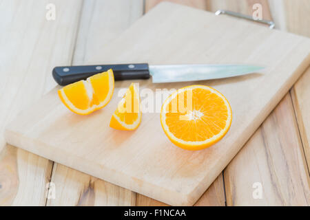 Tranches D'orange Fraîche Et Un Couteau à Fruits Sur Une Planche à Découper  En Bois.