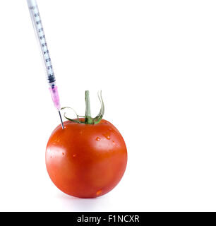 Organisme génétiquement modifié food concept image. Seringue à aiguille injectés à l'intérieur de la tomate Banque D'Images