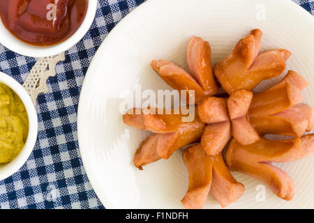 Comme saucisses apéritif plat sur assiette blanche arrière-plan. Banque D'Images