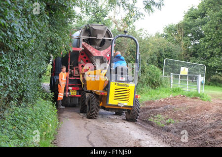 Le déchargement d'un camion de béton dans un étroit chemin de campagne dans un camion-benne pour les petits constructeurs mise sur une ferme Banque D'Images