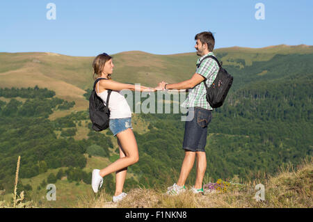 Les randonneurs heureux couple amoureux se tenant par la main dans les montagnes Banque D'Images