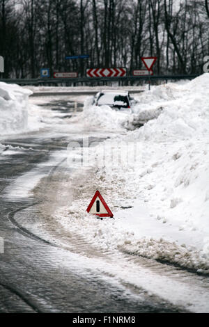 Triangle d'avertissement sur la route d'hiver. Banque D'Images