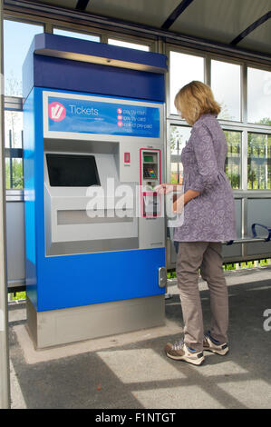 Femme l'achat d'un billet de train à un distributeur automatique de billets, UK Banque D'Images