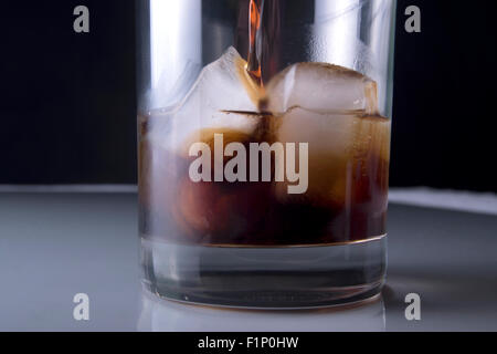 Rum étant versé sur de la glace et la vodka en verre clair Banque D'Images