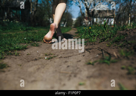 Belle fille jambes suit une route de campagne Banque D'Images