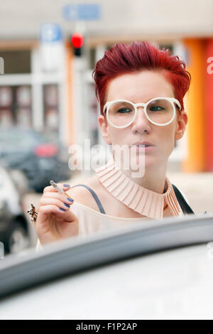 Portrait of red-haired woman smoking a cigarette Banque D'Images
