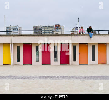 Couple assis au-dessus de la rangée de cabines de plage Le Touquet France Banque D'Images