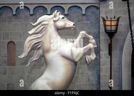 Statue d'un cheval d'élevage avant d'un mur de château Banque D'Images