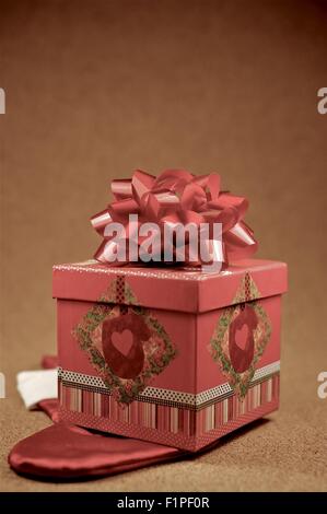 Petit cadeau de Noël - Coffret cadeau décoratif rouge avec noeud sur le dessus. Thème de Noël Banque D'Images