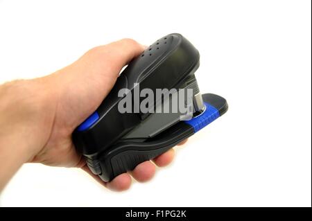 Agrafeuse de bureau en plastique noir dans la main. Arrière-plan blanc séparé. Banque D'Images