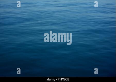 Arrière-plan de surface de l'eau d'un bleu profond. La surface horizontale de l'eau naturelle de la photographie. Banque D'Images