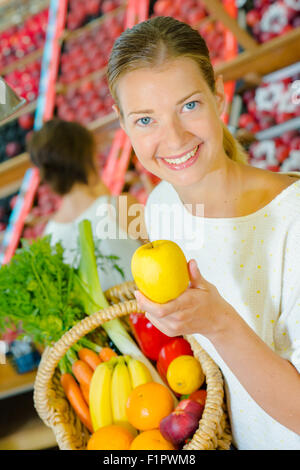 Femme tenant un panier plein de fruits différents Banque D'Images