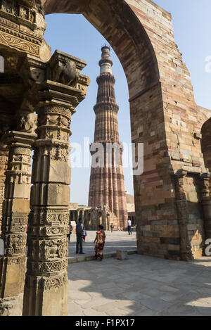 Delhi, Inde. Le Qûtb Minâr tower vu throughan arceau des Quwwat-ul-Islam mosquée Banque D'Images