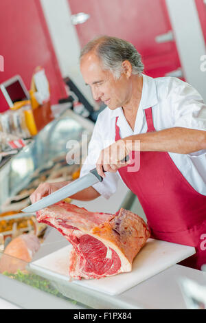 Butcher le tranchage d'une grande coupe de bœuf Banque D'Images