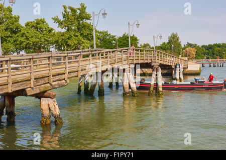 Chaland passant sous le pont en bois reliant Burano à l'île voisine de Mazzorbo Lagune de Venise Vénétie Italie Europe Banque D'Images