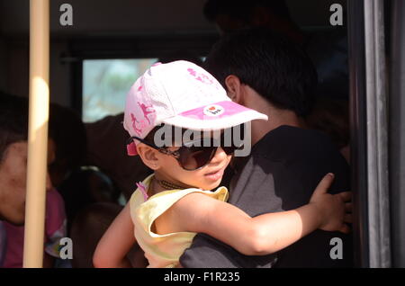 Pirée, Grèce. 06 Sep, 2015. Une fille entre dans un autobus avec son père. Tera Jet ferry est arrivé au port de Pirée transportant 1700 réfugiés syriens de l'île grecque de Lesbos. Crédit : George/Panagakis Pacific Press/Alamy Live News Banque D'Images