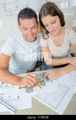 Couple à la recherche sur les plans pour leur nouvelle maison Banque D'Images