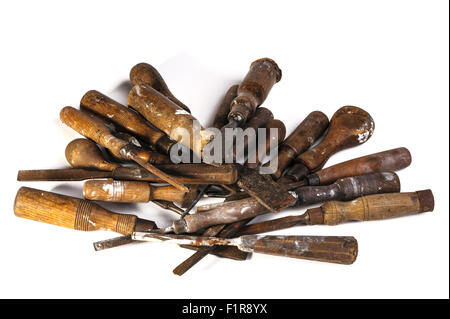 Vieux ciseaux à bois et des tournevis, empilées en tas sur un fond blanc Banque D'Images